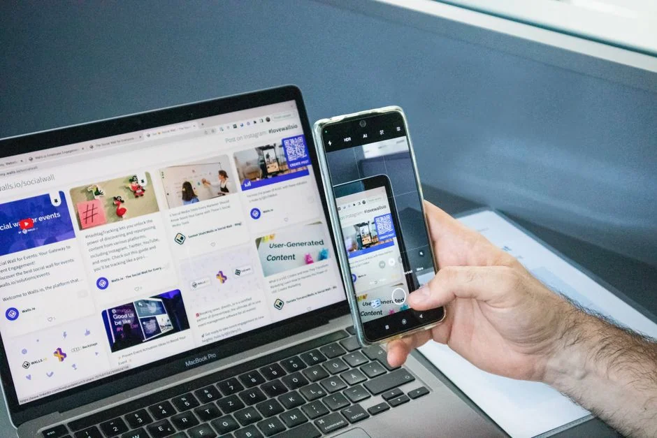 Gros plan sur un carnet contenant des croquis de wireframe et un smartphone posés sur un bureau en bois.